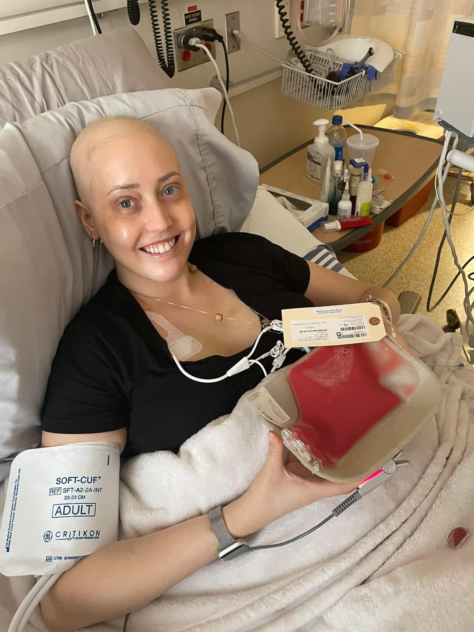 Ashley sur un lit d'hôpital tenant une poche de plasma sanguin