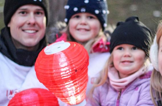 Famille de 4 personnes prenant une photo avec une lanterne Light The Night