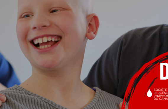 Un garçon souriant tout en sonnant une cloche avec une infirmière.
