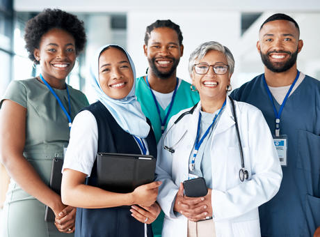 Un groupe de professionnels de la santé se tenant ensemble dans un couloir et souriant