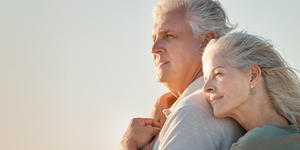 An old man and woman hunging and staring off into the distance