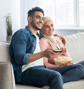 Homme et femme regardant la télévision depuis un canapé