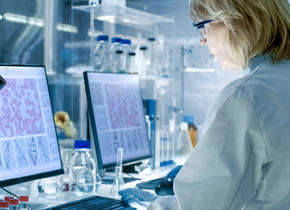 Femme dans un laboratoire, analysant des données sur son ordinateur