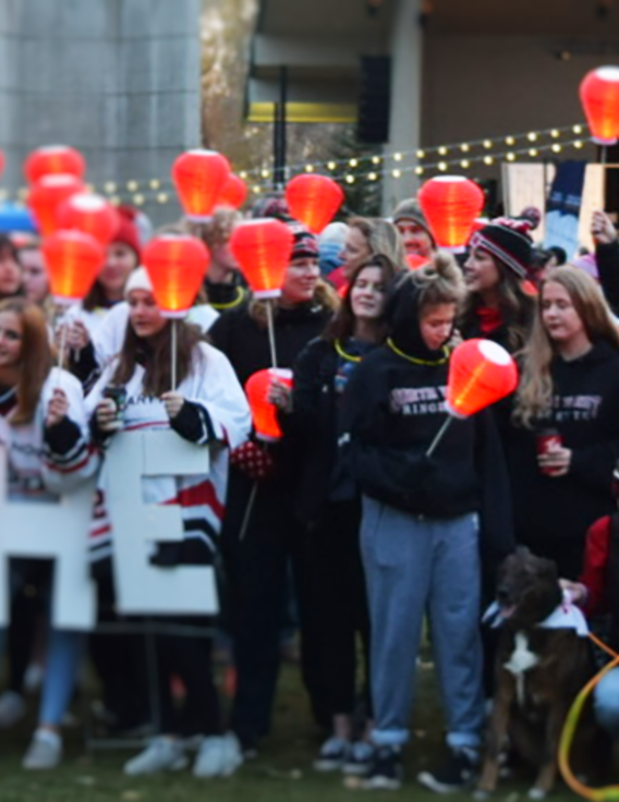 Un groupe de personnes brandissant des lettres en papier « Light The Night ».