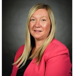 A woman with a black shirt and pink blazer